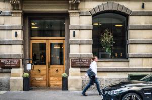 a man walking in front of a building at King Street Townhouse in Manchester