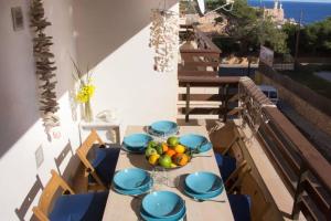 una mesa con platos azules y un bol de fruta en ella en Miramar, en Cala Figuera