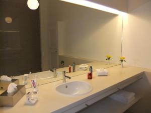 a bathroom with a sink and a large mirror at Schlossparkhotel Mariakirchen in Arnstorf