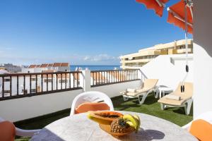 una mesa con un bol de fruta en el balcón en Home2Book Paradise Costa Adeje, Pool, en Playa Fañabe