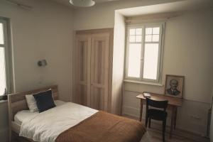 a bedroom with a bed and a desk and a window at Hotel Erica in Langenbruck