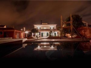 a house with a swimming pool at night at Salt Lips Surf & Coworking Azores in Ponta Delgada