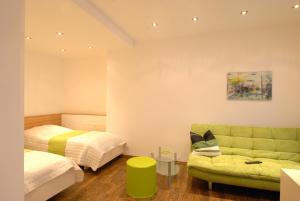 ブルック・アン・デア・ムーアにあるAppartement Haberlのベッドルーム(緑のソファ、ベッド付)