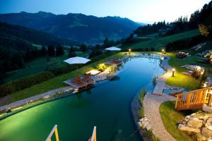 a river with tables and umbrellas on a bridge at Naturhotel Edelweiss Wagrain in Wagrain