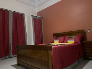 a bedroom with a bed with red curtains at Gîte Le Toubé in Saint-Louis