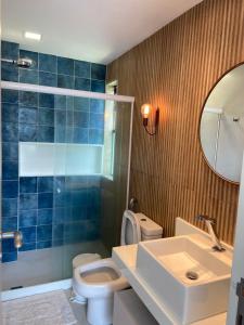 W łazience znajduje się toaleta, umywalka i lustro. w obiekcie Muro alto Bangalô pé na areia w mieście Porto de Galinhas
