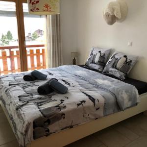 a bed with a comforter and pillows on it at Appartement Haute Nendaz met fantastisch uitzicht in Nendaz +31 photos