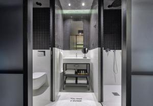 ein Badezimmer mit Waschbecken, Toilette und Spiegel in der Unterkunft ONOMA Hotel in Thessaloniki
