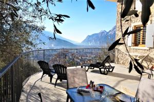 uma varanda com cadeiras, uma mesa e vista para as montanhas em Chalet Laghel em Arco