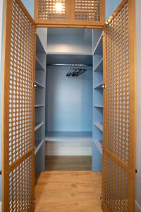 einen begehbaren Kleiderschrank mit blauen Wänden und Holztüren in der Unterkunft HCG Art'Muse Apartment in Batumi