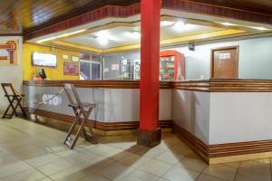 a bar in a restaurant with a red pole at OYO New Anápolis Hotel, Imperatriz in Imperatriz