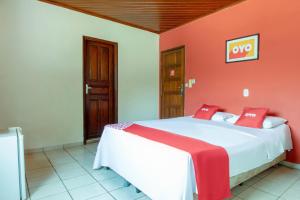 a bedroom with a large bed with red walls at OYO New Anápolis Hotel, Imperatriz in Imperatriz