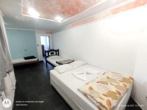 een kleine kamer met 2 bedden in een kamer bij Grande Hotel Estação Norte in Benfica