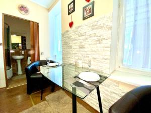 a room with a glass table and chairs and a stone wall at ApartPoltava Будиночок з мангалом та терасою, Оглядовий майданчик, банківський чек in Poltava