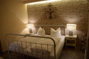 ein Schlafzimmer mit einem Bett mit weißen Kissen und einer Ziegelwand in der Unterkunft Hotel Arte Vida OHG in Spremberg