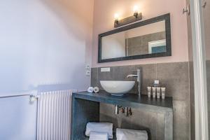 a bathroom with a sink and a mirror on the wall at Le Relais Des Chartreuses in Le Boulou