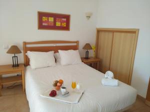 a bed with a tray of fruit on it at Club House CVL in Luz