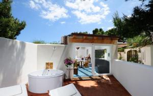 a bath tub sitting on a patio next to a house at Le Calette Bay in Cefalù