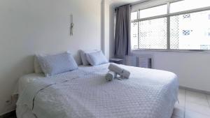a bedroom with a bed with a stuffed animal on it at Rio Spot Homes Leblon U042 in Rio de Janeiro