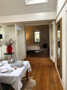 a dining room with a table and a bedroom at B&B de Tol in Hulst