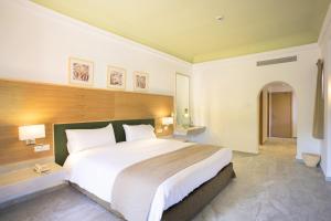 - une chambre avec un grand lit dans une chambre d'hôtel dans l'établissement Hotel Riu Tikida Palmeraie - All Inclusive, à Marrakech