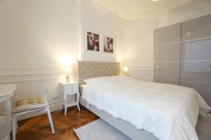 a white bedroom with a bed and a table and a chair at Modern Duplex Close To The Eiffel Tower in Paris