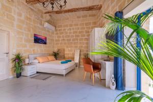 a living room with a white couch and a brick wall at Fiftyfour West Boutique Living in Għarb