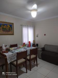 a living room with a table and a couch at Praia grande canto do forte top in Praia Grande