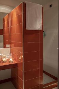 a shower in a bathroom with brown tiles at Hotel Remilia in Reggio Emilia