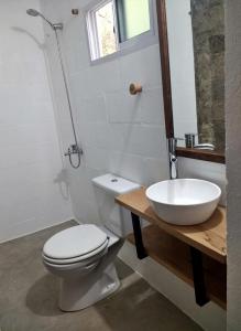 a bathroom with a white toilet and a sink at Aloja Merlo in Merlo