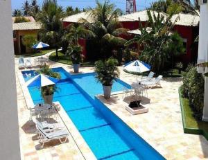 an overhead view of a swimming pool with chairs and umbrellas at Sonia Flats Arituba Tropical - Flat vista mar em frente à Praia de Camurupim in Nísia Floresta