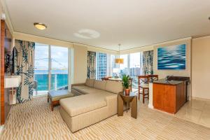 un soggiorno con divano e tavolo di Hotel International Beach Tump Resort Ocean View 1100 sf 1 Bed 1Bth Privately Owned Sunny Isles a Miami Beach