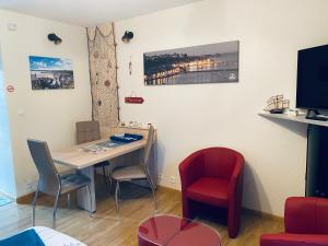 a room with a table and chairs and a television at STUDIO CANCALE - PORT DE LA HOULE - classé 2 étoiles in Cancale