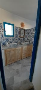a bathroom with two sinks and a mirror at Dar Chick Yahia Ile De Djerba in Mezrane