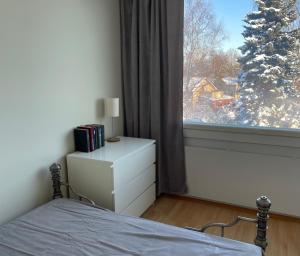 Dormitorio con cama y ventana con árbol de Navidad en Park View Apart, en Kouvola