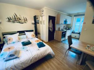 a bedroom with a bed and a table and a kitchen at STUDIO CANCALE - PORT DE LA HOULE - classé 2 étoiles in Cancale