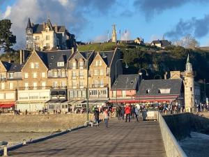 a group of people walking on a pier with a castle in the background at STUDIO CANCALE - PORT DE LA HOULE - classé 2 étoiles in Cancale