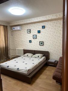 Un dormitorio con una cama y una pared con cuadros. en Apartments on Otradnaya and Kho Shi Mina, en Ulyanovsk