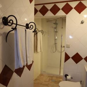 a bathroom with a shower and a toilet and towels at Hotel Portofoz in Porto