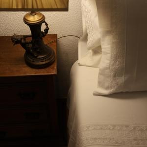 a lamp on a night stand next to a bed at Hotel Portofoz in Porto