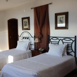 a bedroom with two beds with white sheets at Hotel Portofoz in Porto