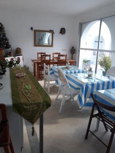 a dining room with blue and white tables and chairs at Dar Chick Yahia Ile De Djerba in Mezrane