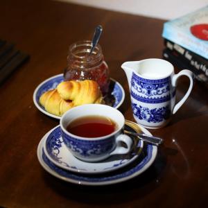 a table with a cup of tea and a plate of pastries at Hotel Portofoz in Porto