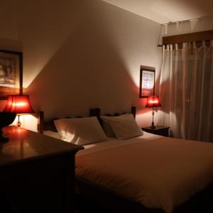a bedroom with a white bed and two lamps at Hotel Portofoz in Porto