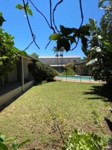 a lawn in front of a building with a tennis court at Savoy Hotel in Fort Beaufort