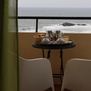 uma bandeja de comida numa mesa com vista para o oceano em Hotel Portofoz em Porto