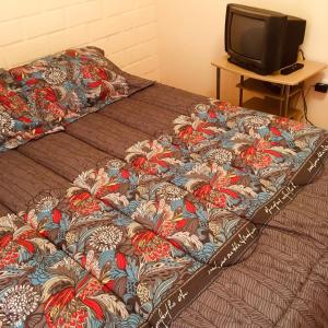 1 cama con edredón y mesa con TV en Cabaña Vicuña en Vicuña