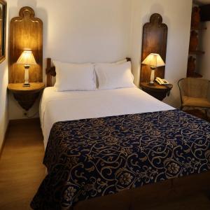 a bed in a hotel room with two lamps at Hotel Portofoz in Porto