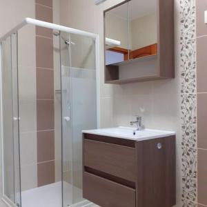 łazienka z umywalką i przeszkloną kabiną prysznicową w obiekcie Apartments Annamaria w Hévízie