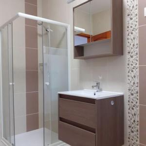 a bathroom with a sink and a glass shower at Apartments Annamaria in Hévíz